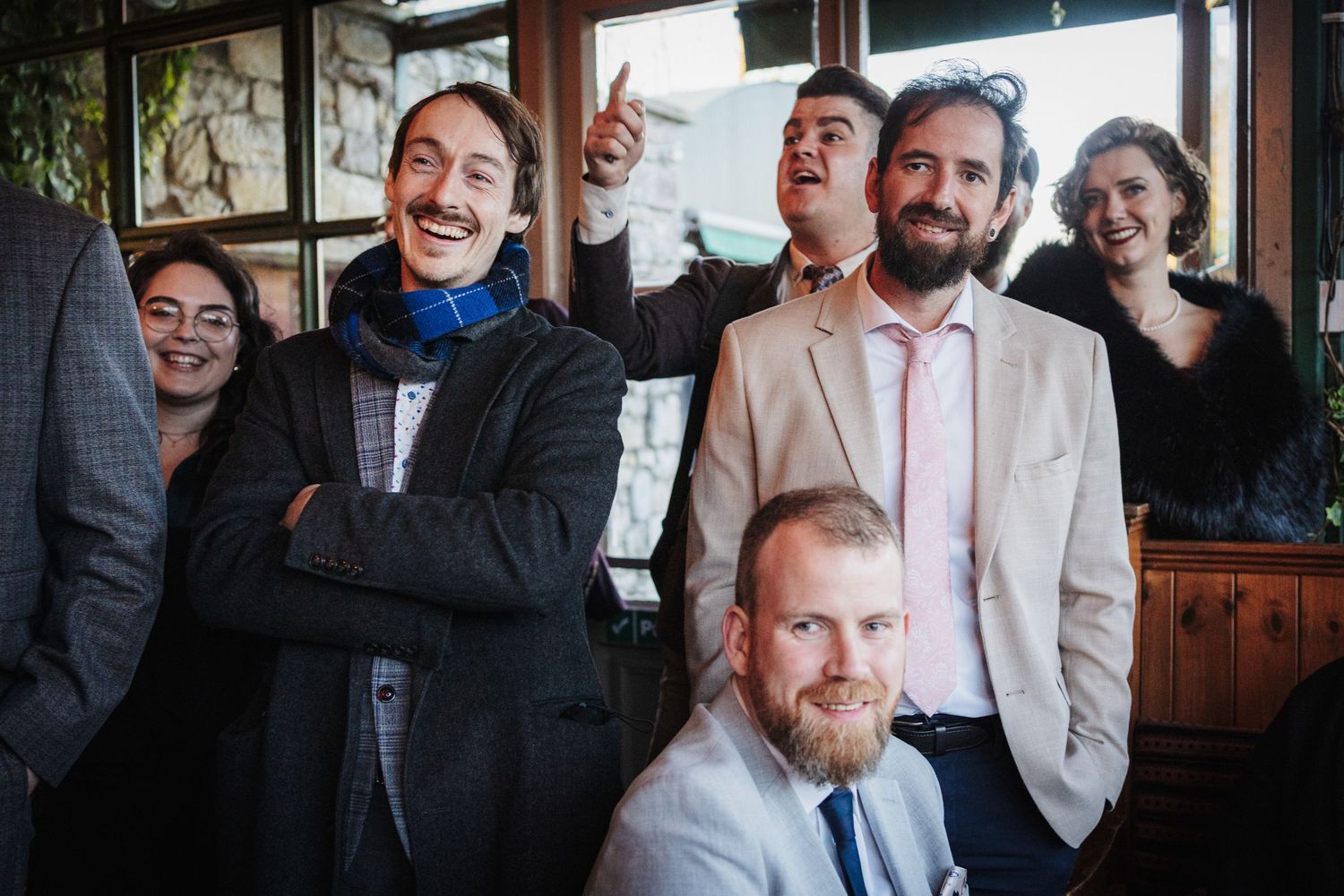 A group of people laughing and having fun together in what appears to be a restaurant or bar setting.