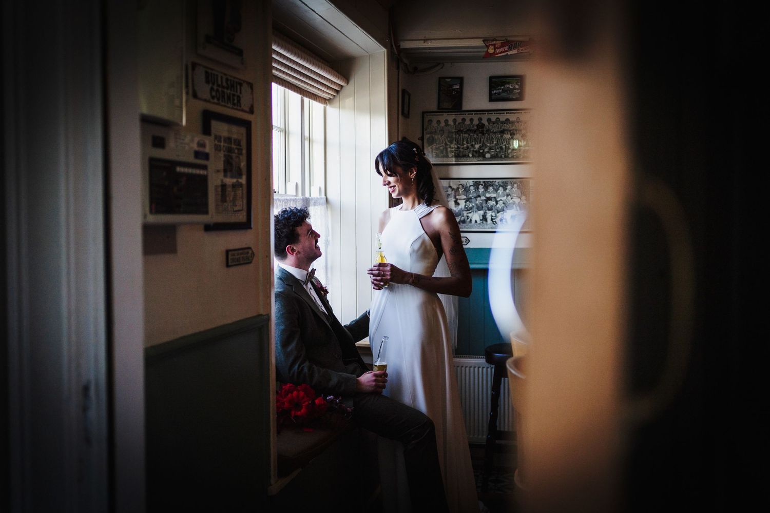 Silhouetted figures in dark interior spaces create dramatic wedding day moments.