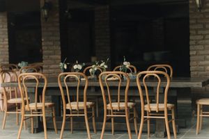 Empty cafe interior with wooden chairs and exposed brick walls illuminated by warm lighting.