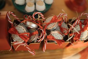 A festive arrangement of candy canes and silver ornaments displayed on a wooden surface.