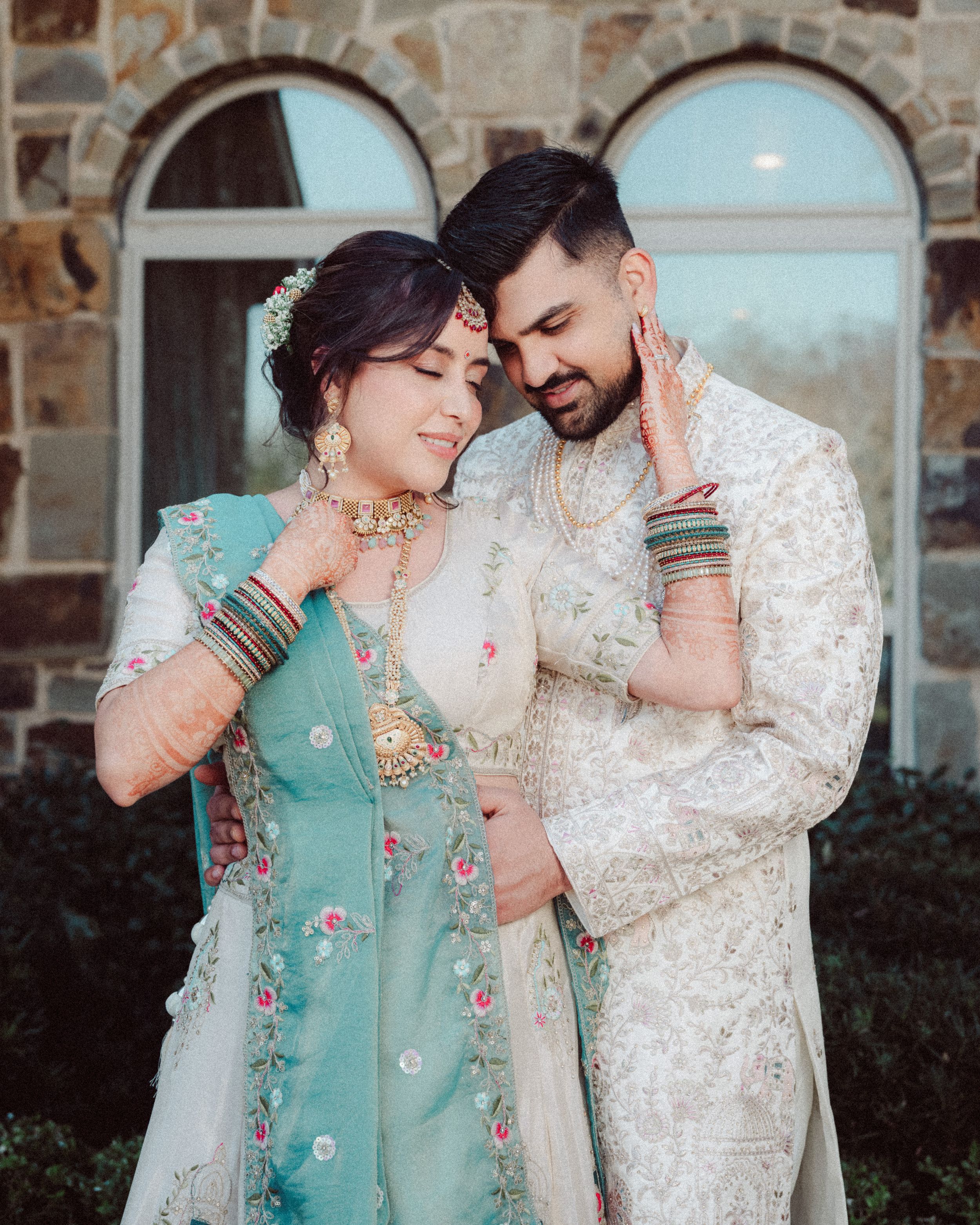 A romantic couple in traditional South Asian attire share intimate moments in a series of outdoor portraits.