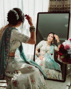A person in a mint green floral dress poses gracefully in front of a mirror in a series of artistic shots.