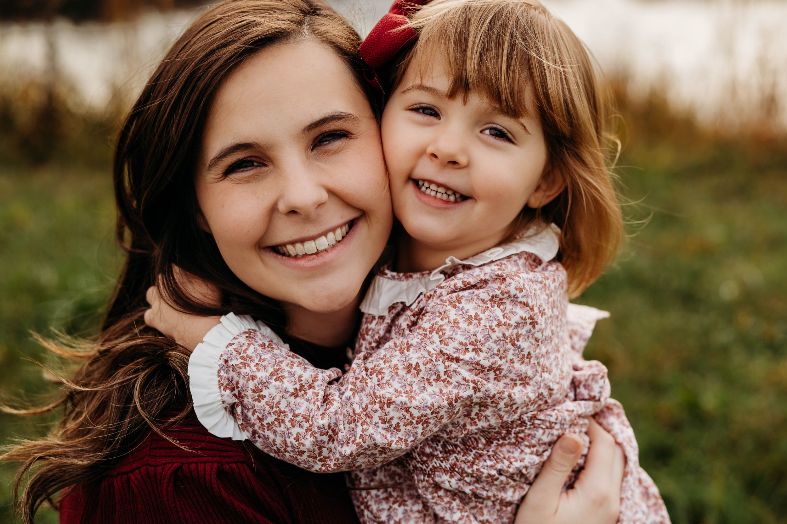 A tender moment captured outdoors showing affection and joy between a parent and child in autumn.