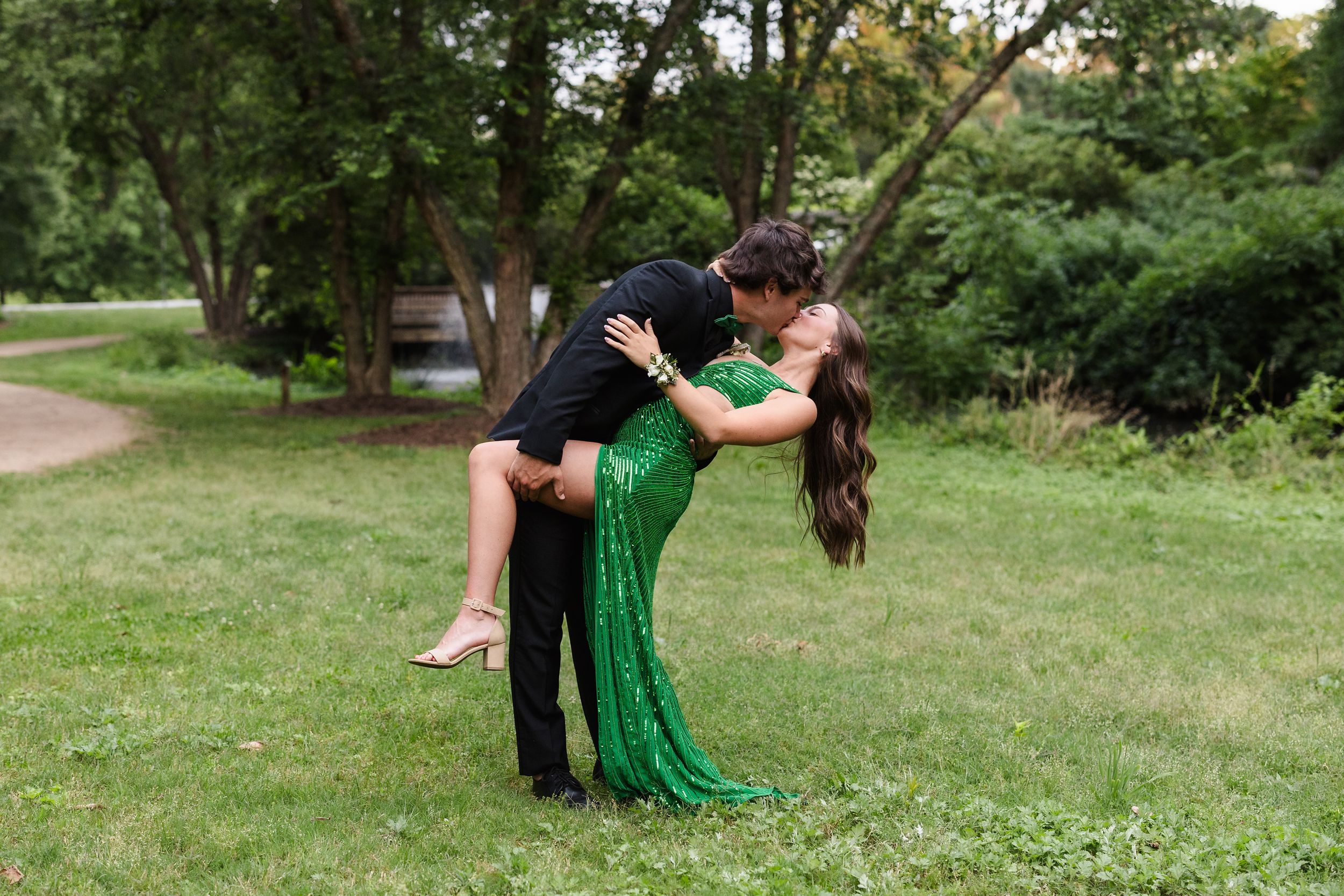 Celebratory graduation poses captured in a lush green park.