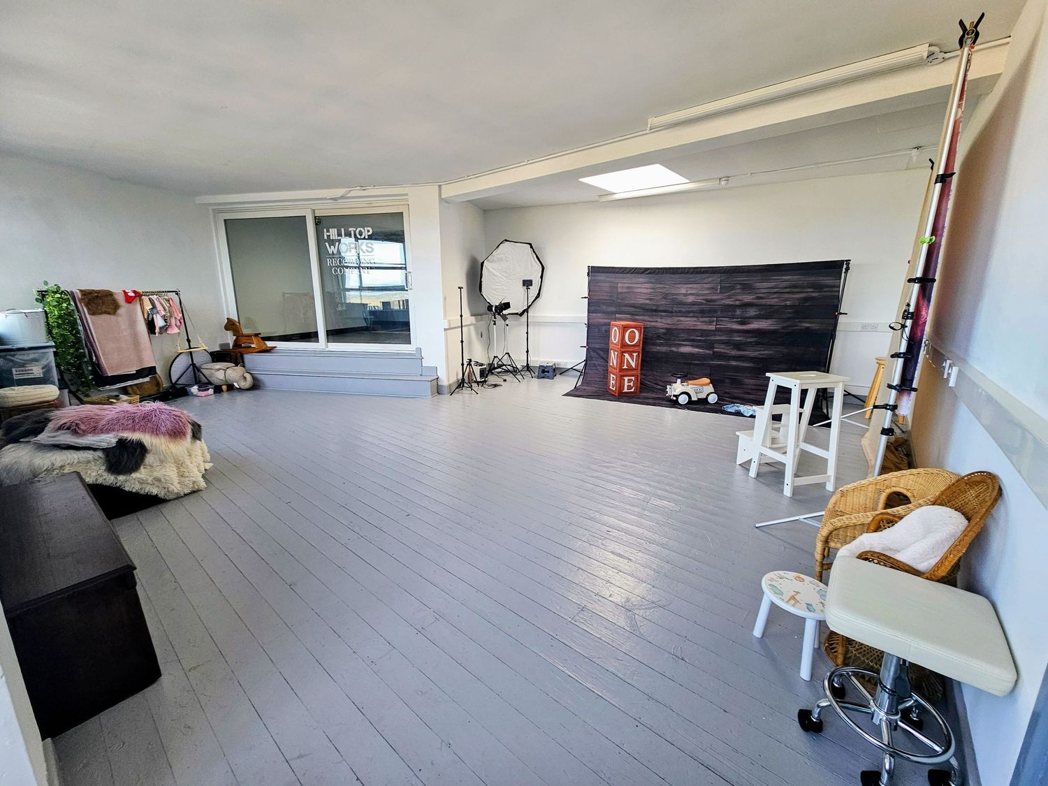 Empty white dance studio with hardwood floors and fluorescent lighting shown from multiple angles.