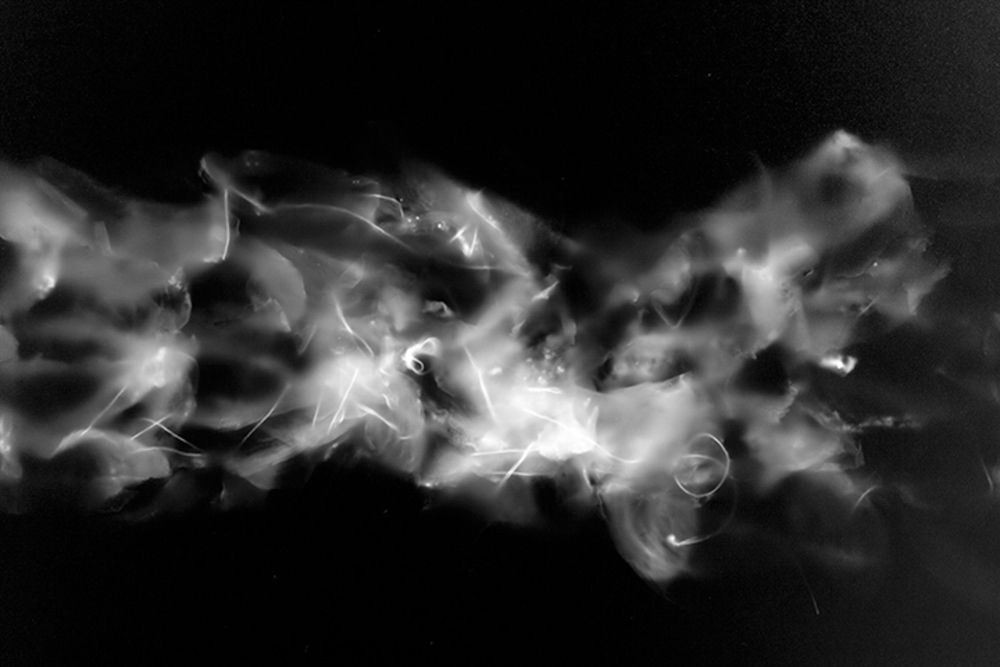 Series of ethereal white smoke or cloud formations against black background.