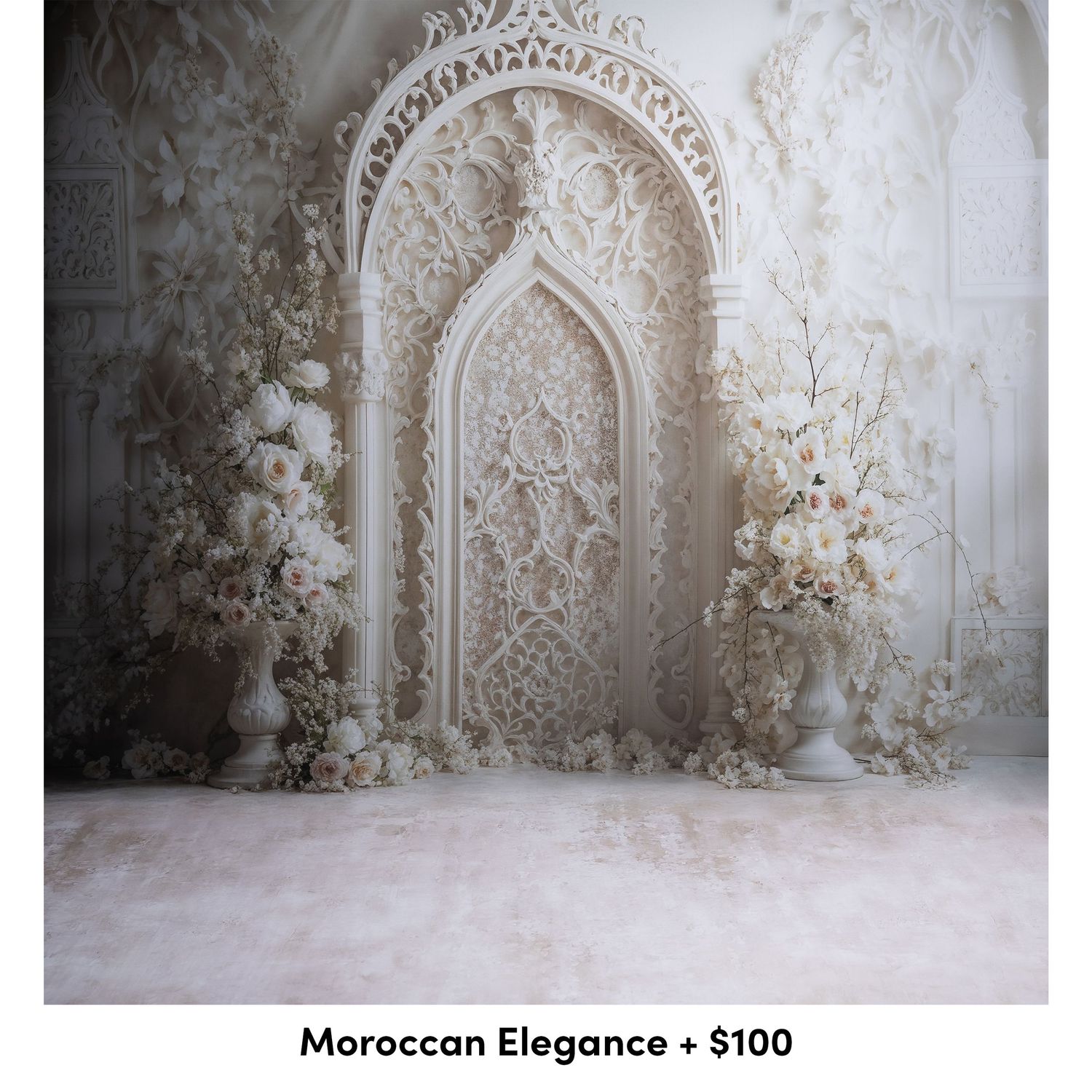Elegant white Moroccan-style archway backdrop with intricate lace patterns and delicate floral arrangements against a light wall.