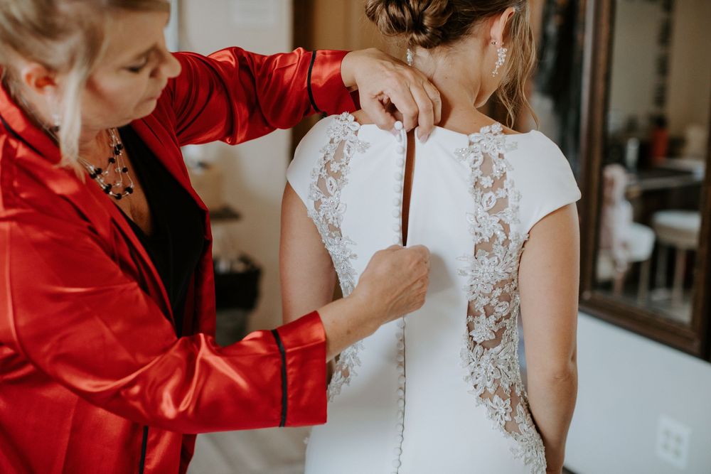 Wedding dress details with red accent in indoor setting.