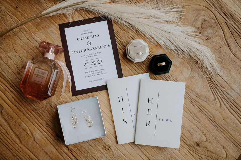 Wedding stationery and invitations displayed on light wooden surface.