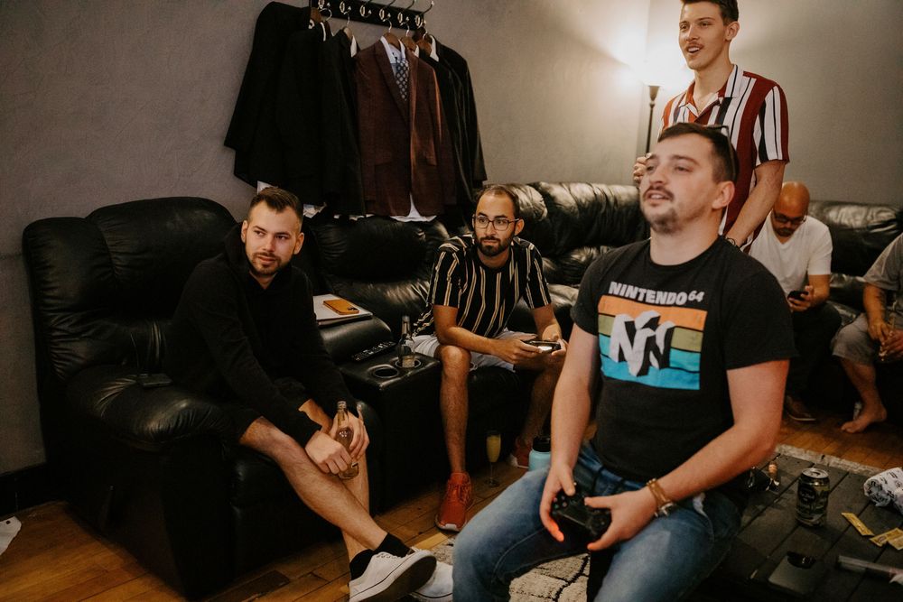 A casual gathering of people sitting in a dimly lit room with relaxed atmosphere.