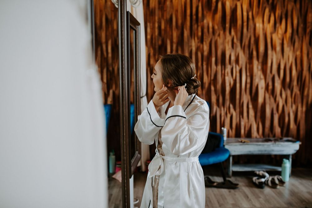 Getting ready scene with white robes against textured brown wall.