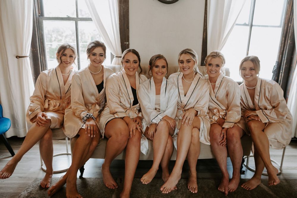 Row of white robes hanging by window with natural light streaming in.