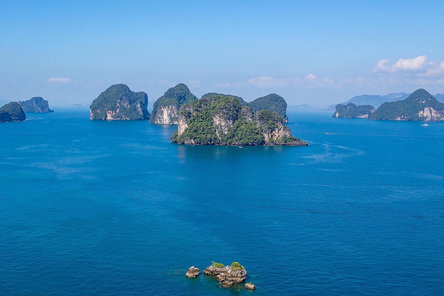 Aerial panorama of limestone islands and turquoise waters in the Andaman Sea off the coast of Thailand.
