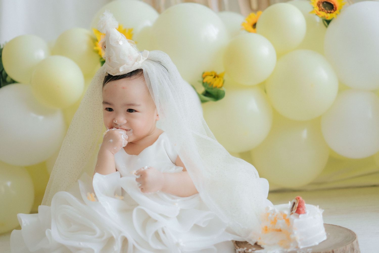 White balloons create an elegant backdrop for a festive celebration with delicate floral accents.