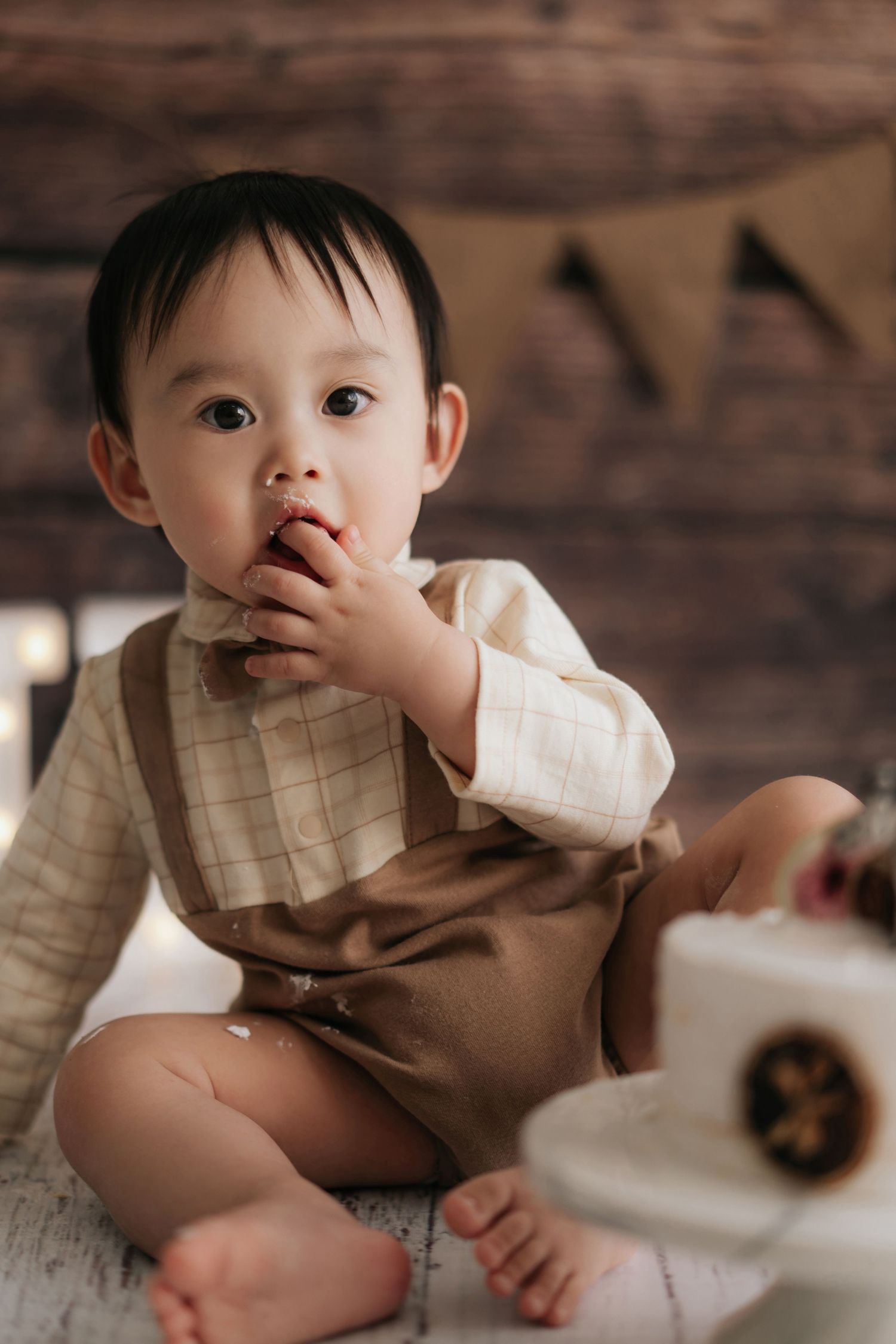 A vintage-style photo setup with wooden backdrop and decorative elements in warm brown tones.