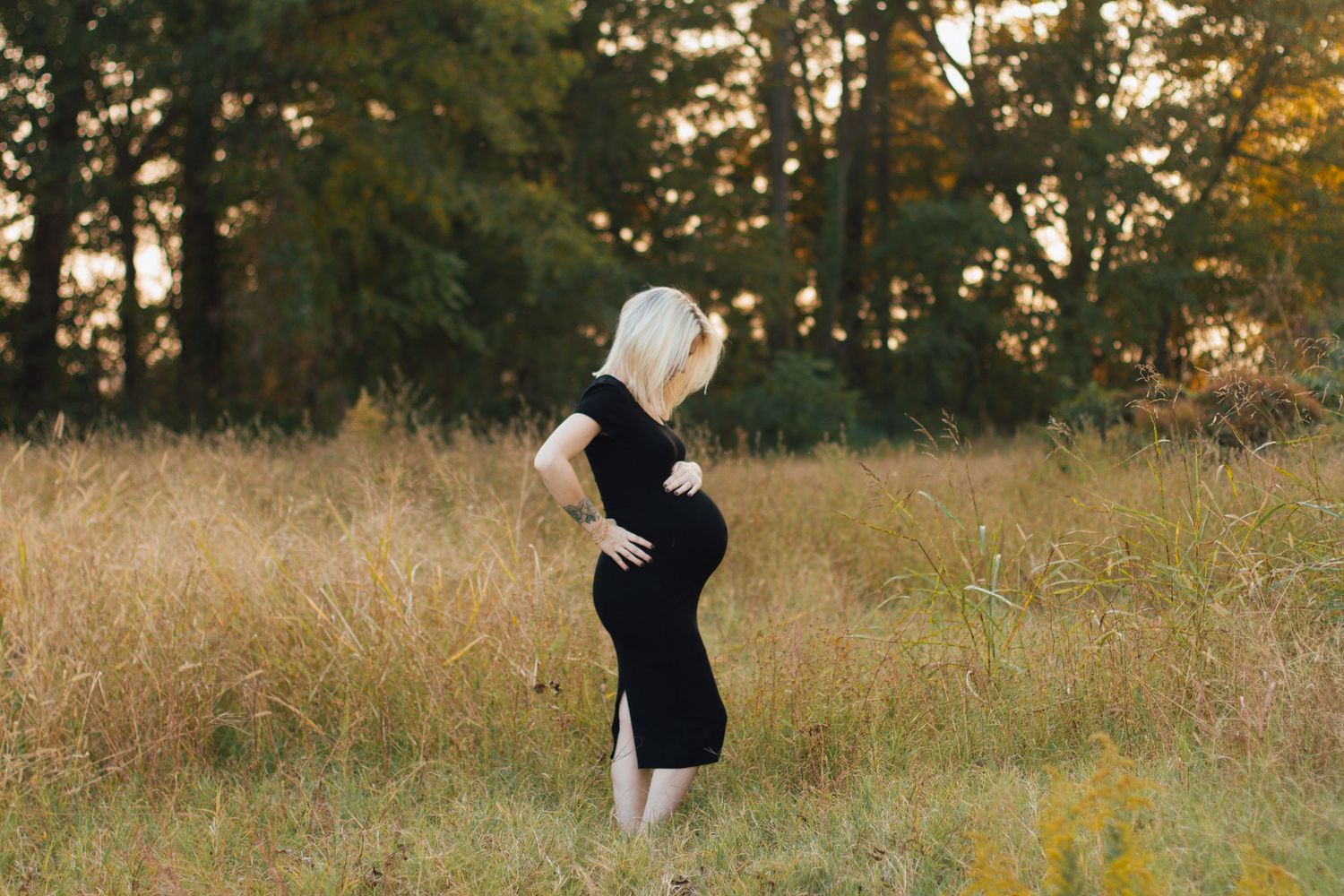 a pregnant mother in a field photographed by Delta Blossoms Photography in Manila, Arkansas