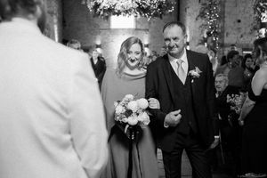 A series of black and white wedding photos showing dancing, celebration and joyful moments at an indoor reception.