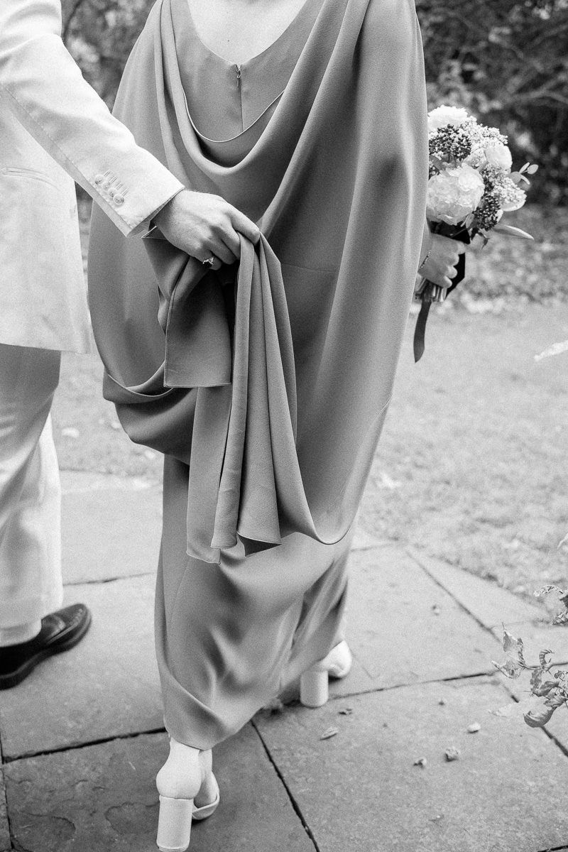 A series of black and white photos showing the elegant draping and movement of formal gowns at an outdoor event.