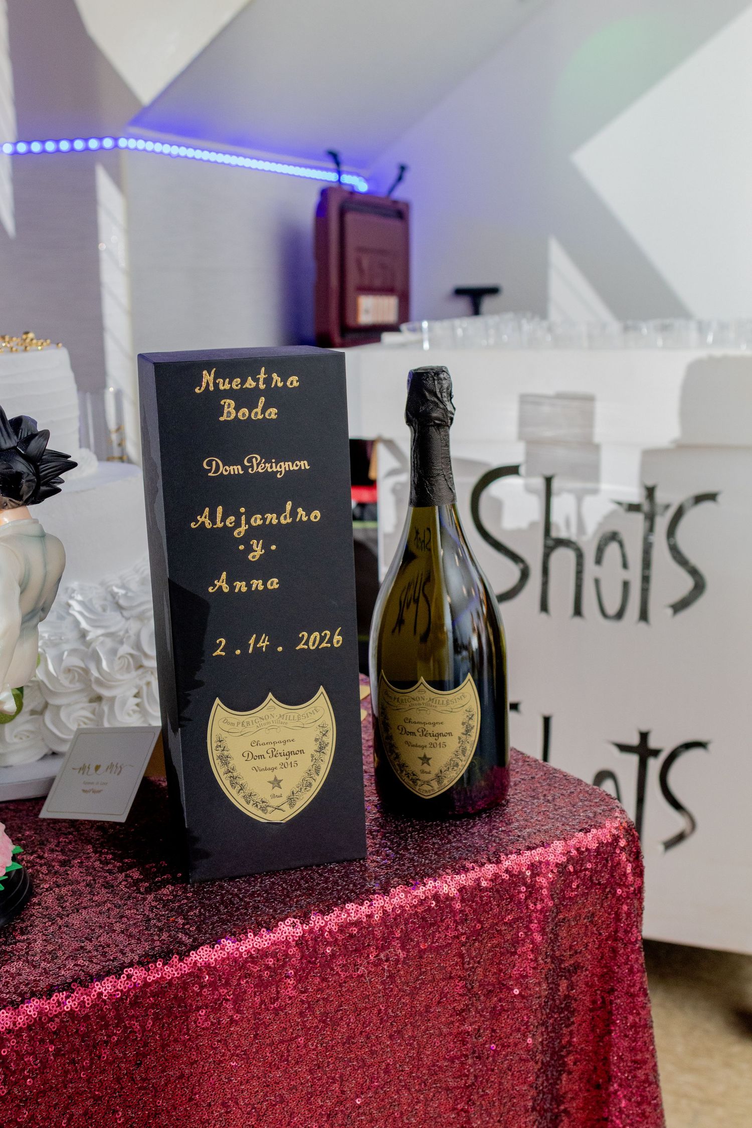 Black and gold champagne bottle display for a wedding reception in Quinlan, Texas, with personalized signage and elegant details.