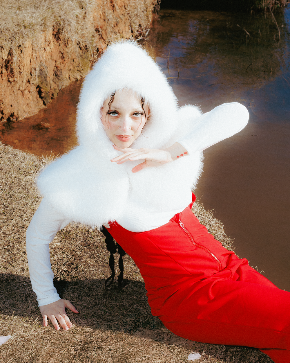 Dramatic poses captured against an earthy backdrop featuring red and white winter fashion styling.