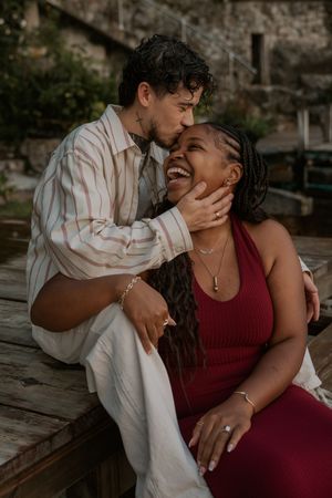 A couple shares intimate romantic moments on a rustic wooden deck in a series of candid photographs.