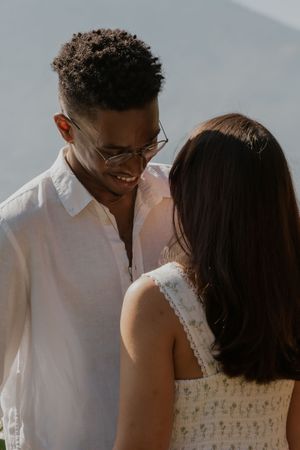 A couple shares an intimate moment on a sunny day, with soft lighting creating a romantic atmosphere.