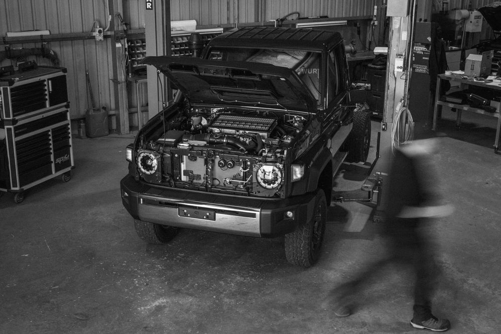 Classic cars parked inside a dimly lit garage or workshop space.