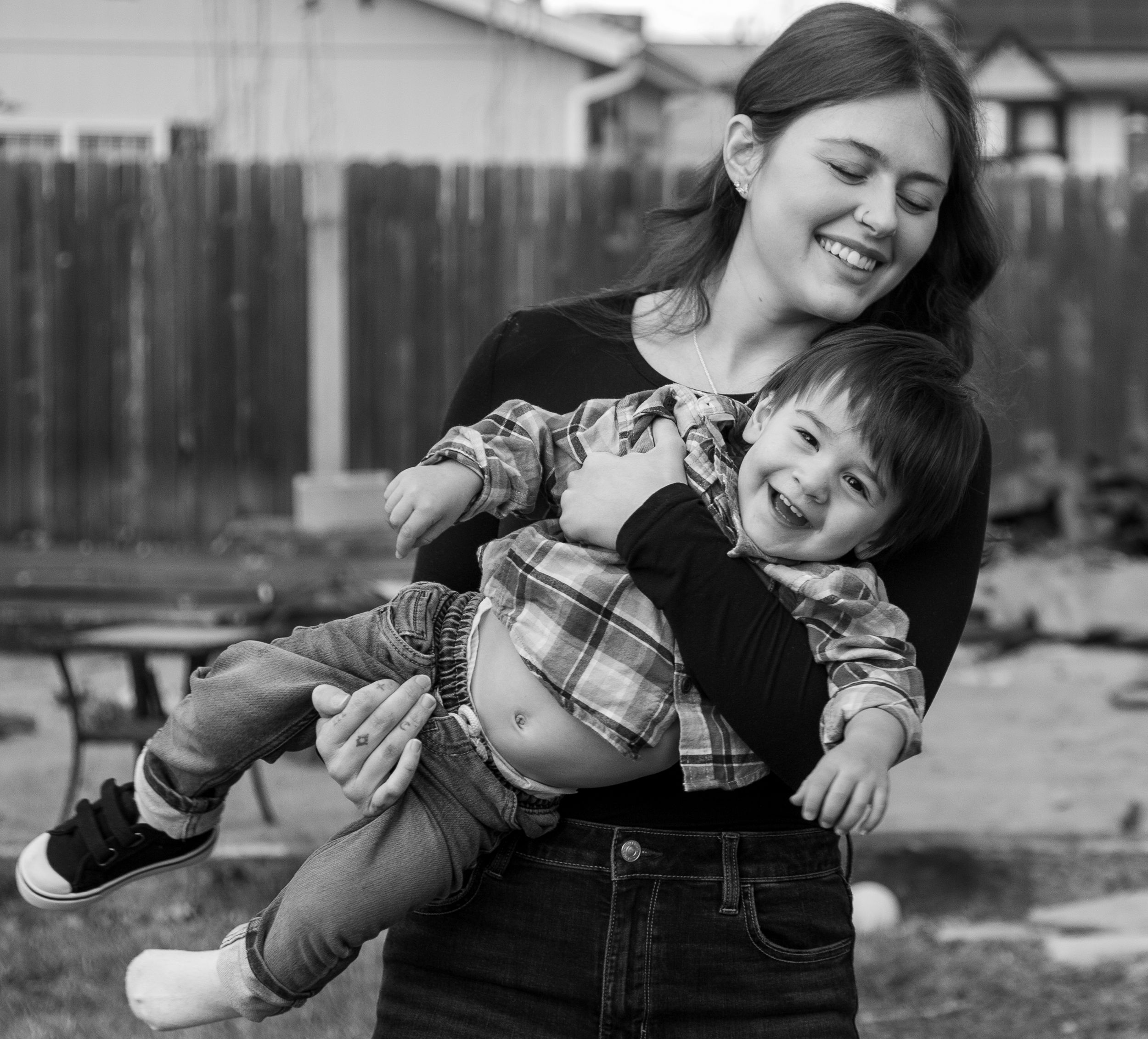 Mother holding son as he laughs.