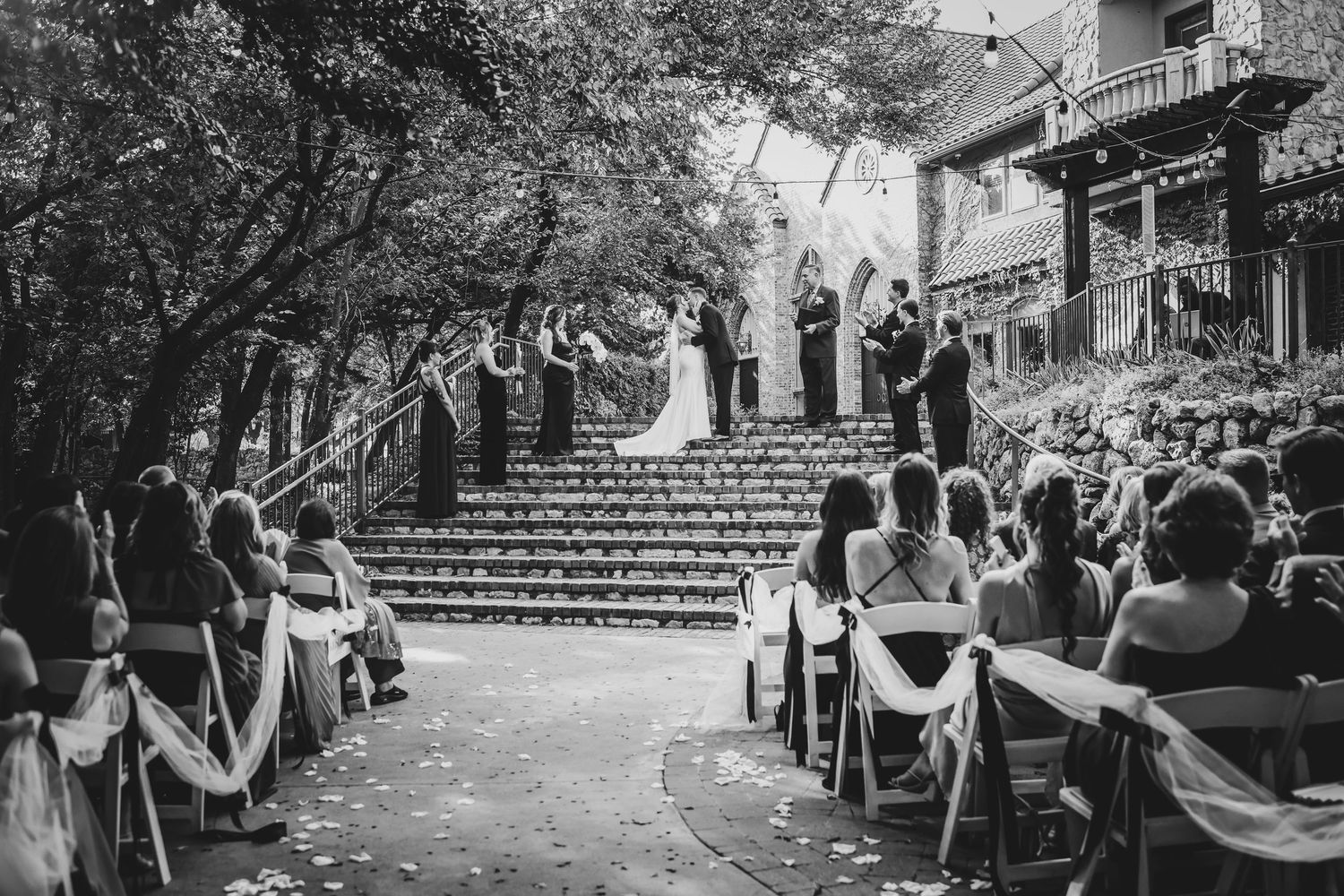 Elegant outdoor wedding ceremony with wooden chairs and floral aisle decor