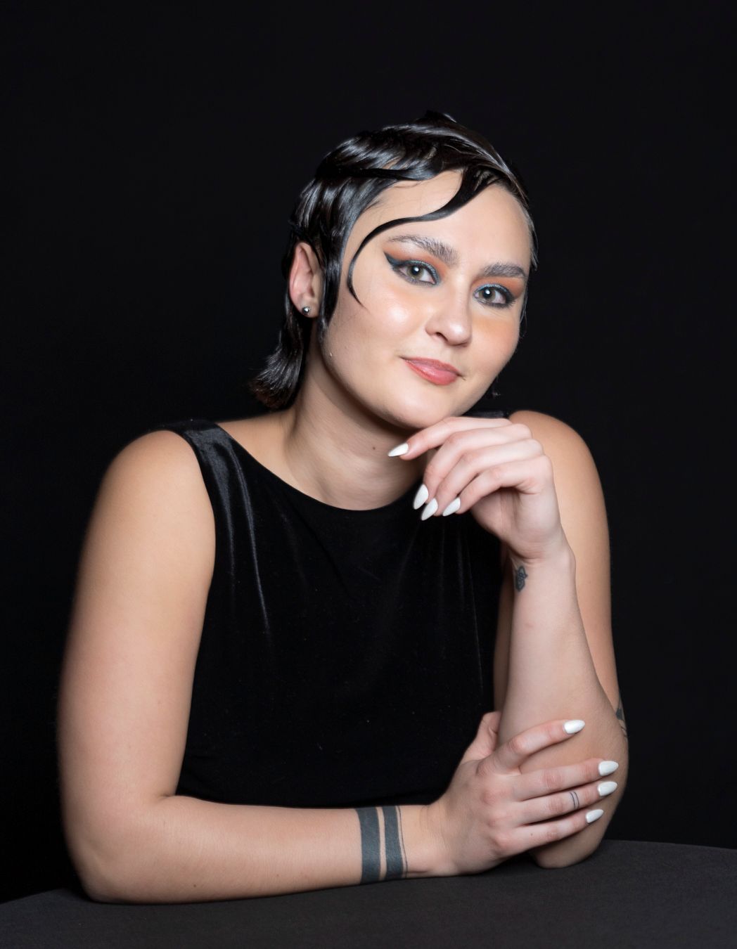 Artistic black and white portrait series showing a person in dark clothing against a black background.