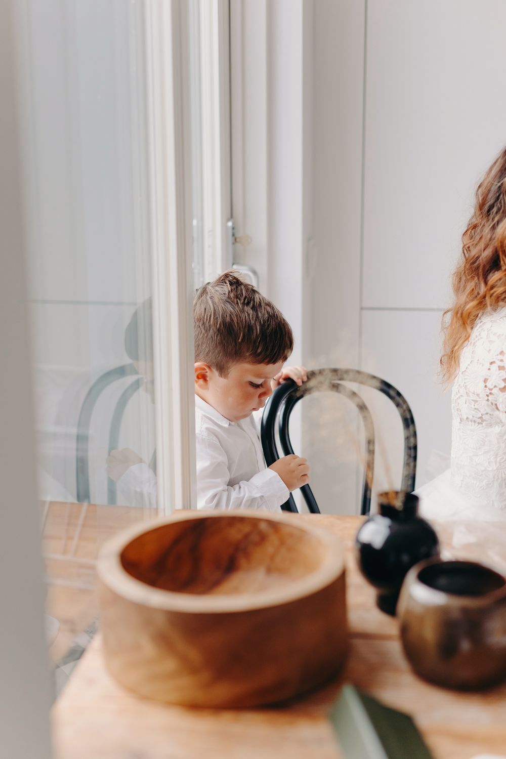 A series of blurred candid photos showing people sitting at a wooden table with bowls and dishes in a bright room.
