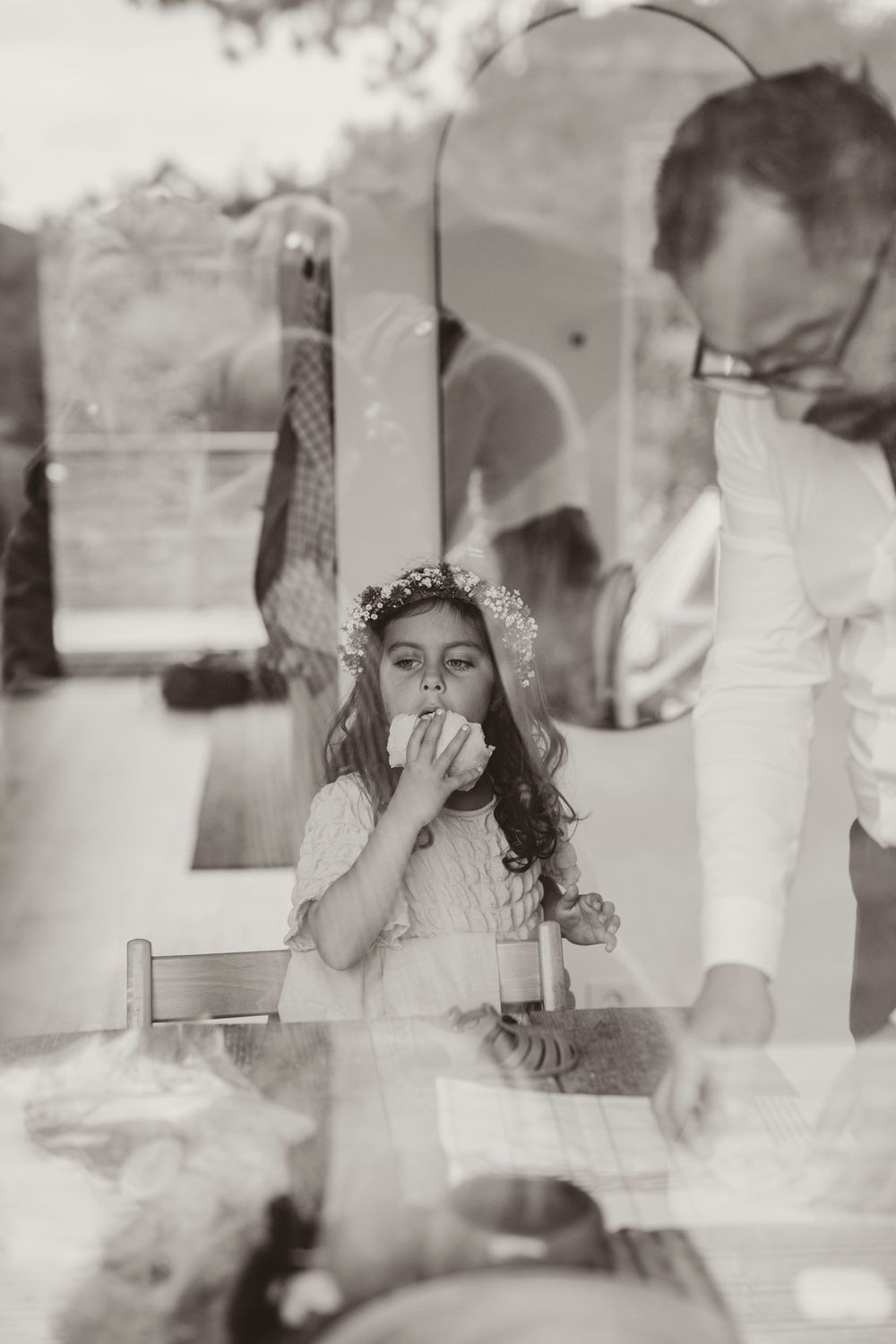 A series of vintage black and white photos showing a child in a lace headpiece eating cake at a special occasion.