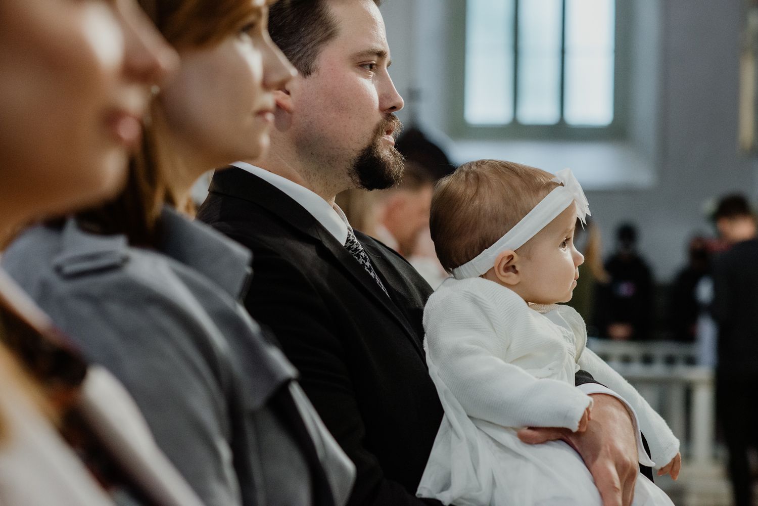 Diverse group of people sitting in a row at a conference or meeting while taking notes and listening attentively.