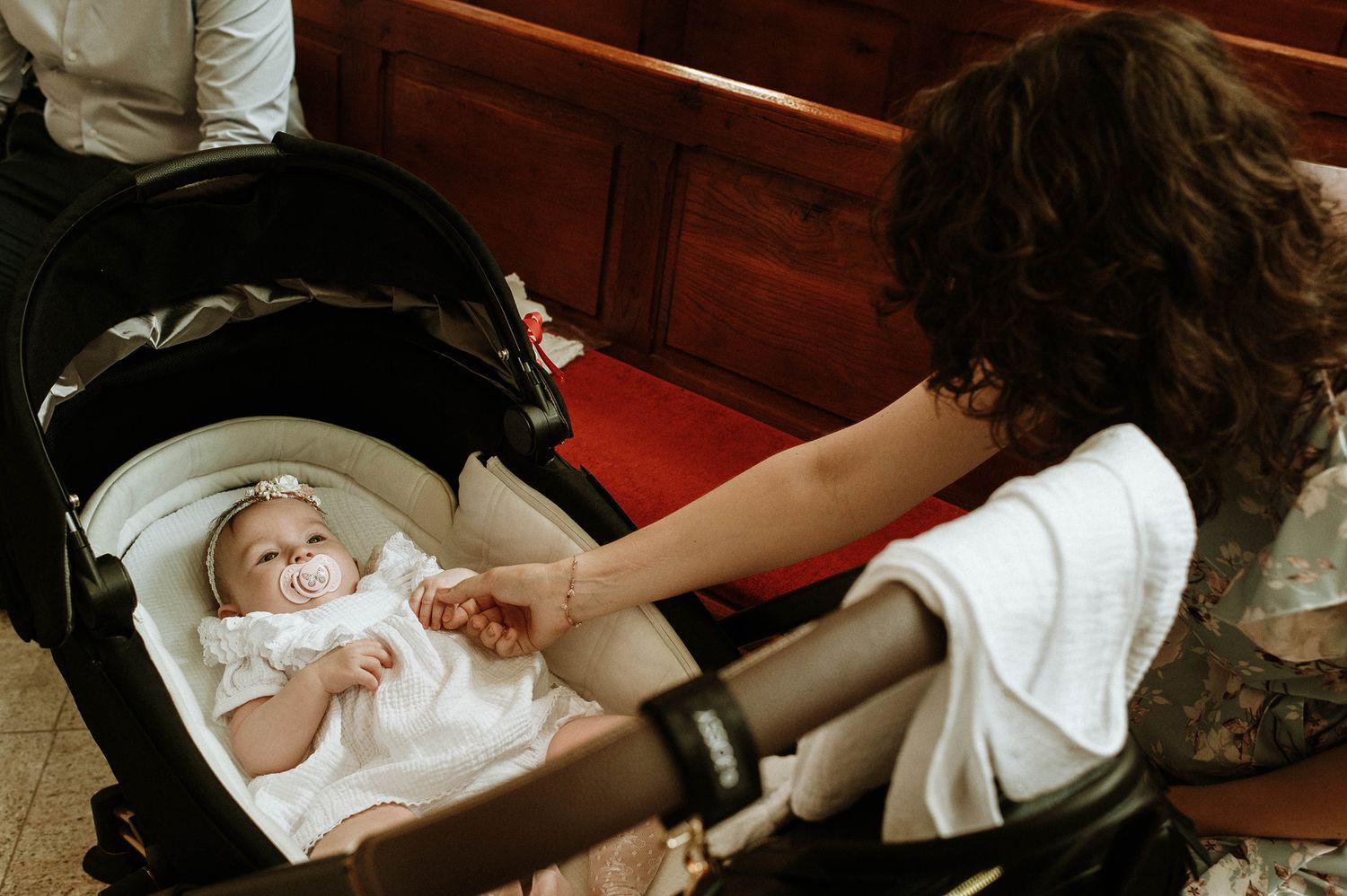 A sequence of photos showing a baby being swaddled in a white blanket on a wooden surface.