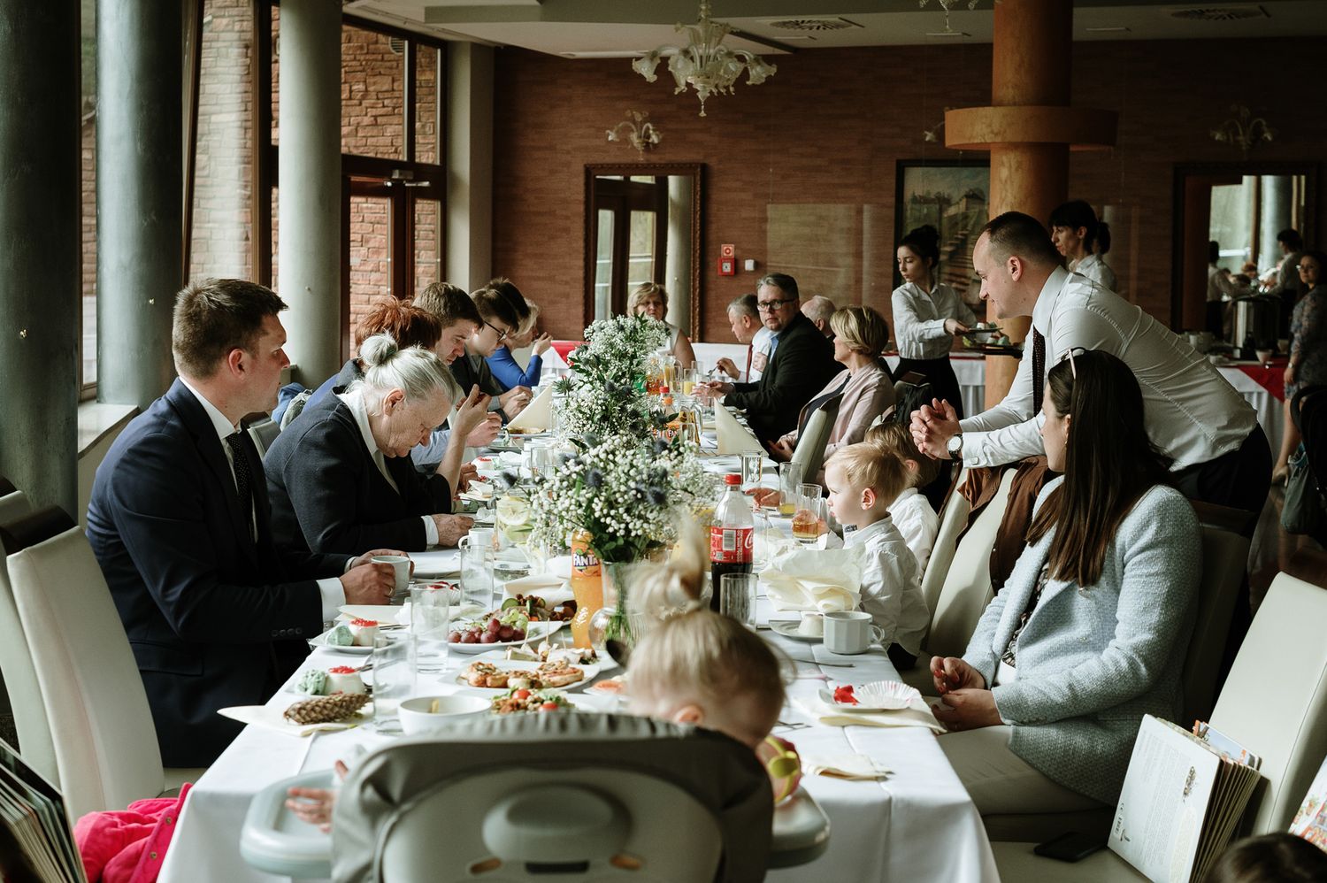 Wedding reception guests seated at elegantly decorated tables in a formal dining room.