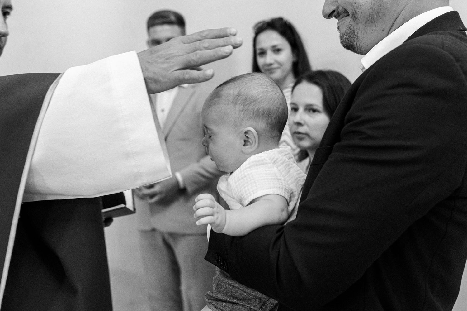 A series of black and white photos showing tender moments between parent and child during a photoshoot.