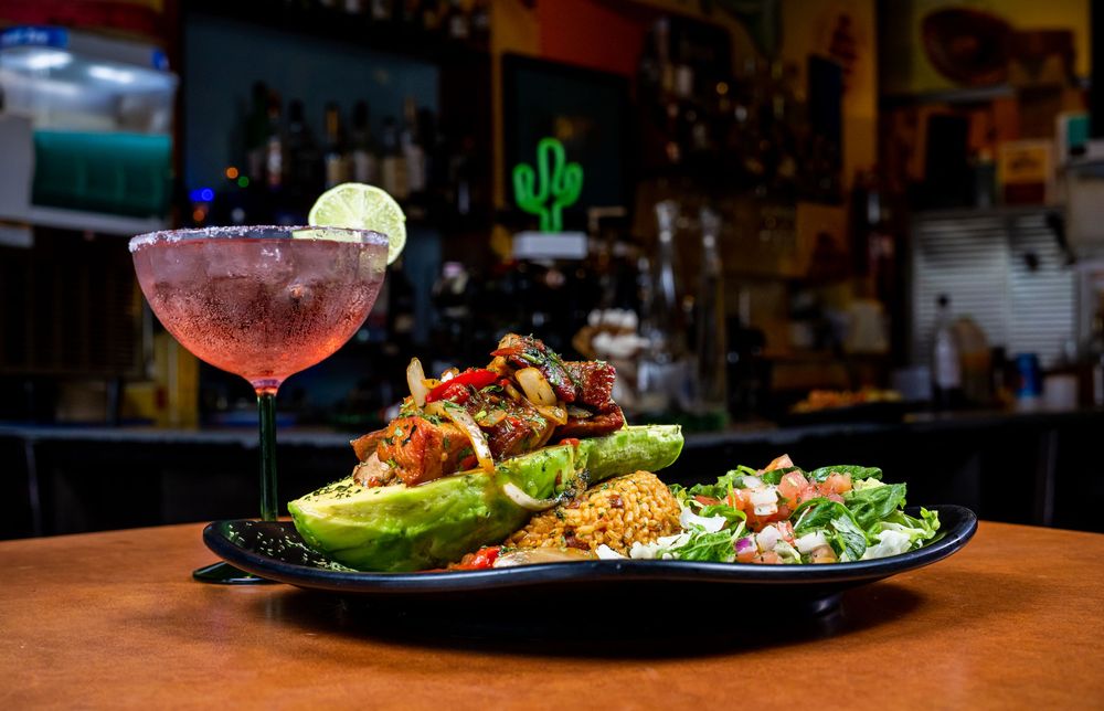 Vibrant Korean BBQ dishes arranged on dark plates with colorful garnishes and sauces in a dimly lit setting.