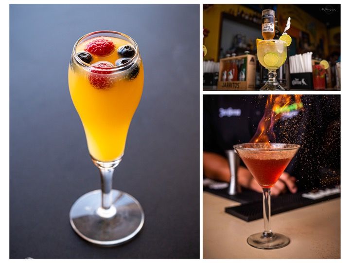 Elegant cocktails in stemmed glasses featuring vibrant colors and fresh garnishes on a dark bar counter.