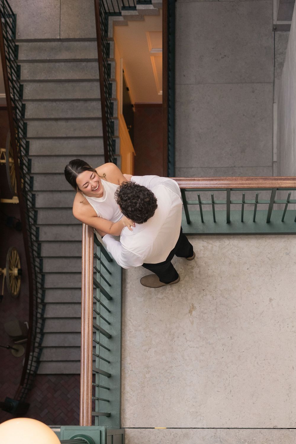 A person in white clothing performs acrobatic moves on a staircase railing in an urban setting.