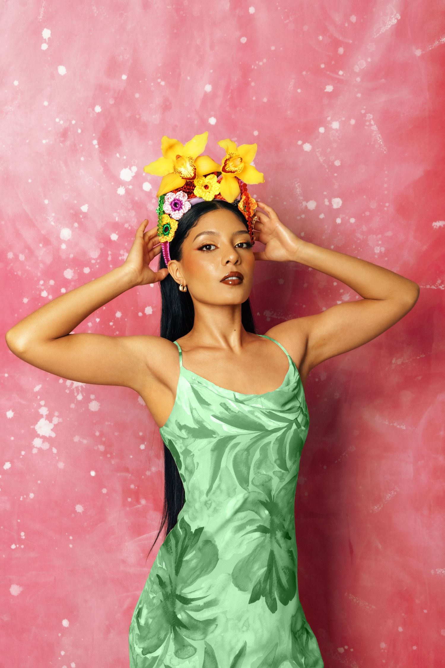 Artistic portrait series against pink sparkly backdrop wearing mint green dress and yellow flowers.