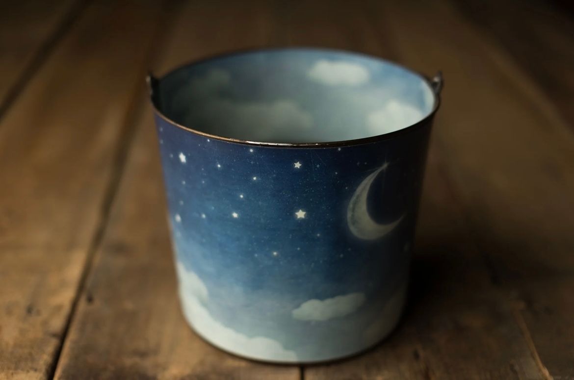 Handmade ceramic bowls with dreamy night sky and moon designs displayed on a rustic wooden surface.