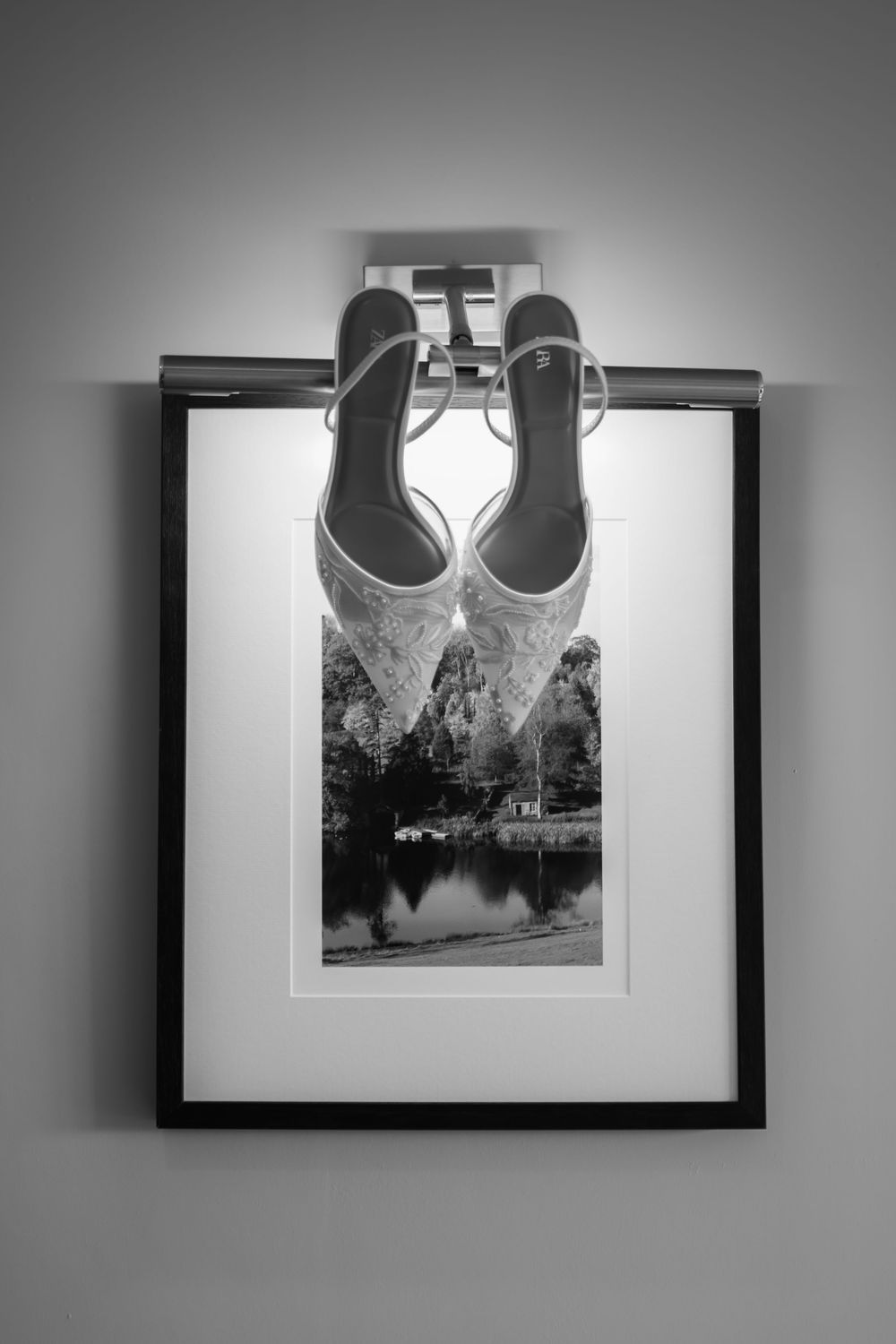 A sequence of black and white photographs hanging on a wall showing architectural details and framed artwork.