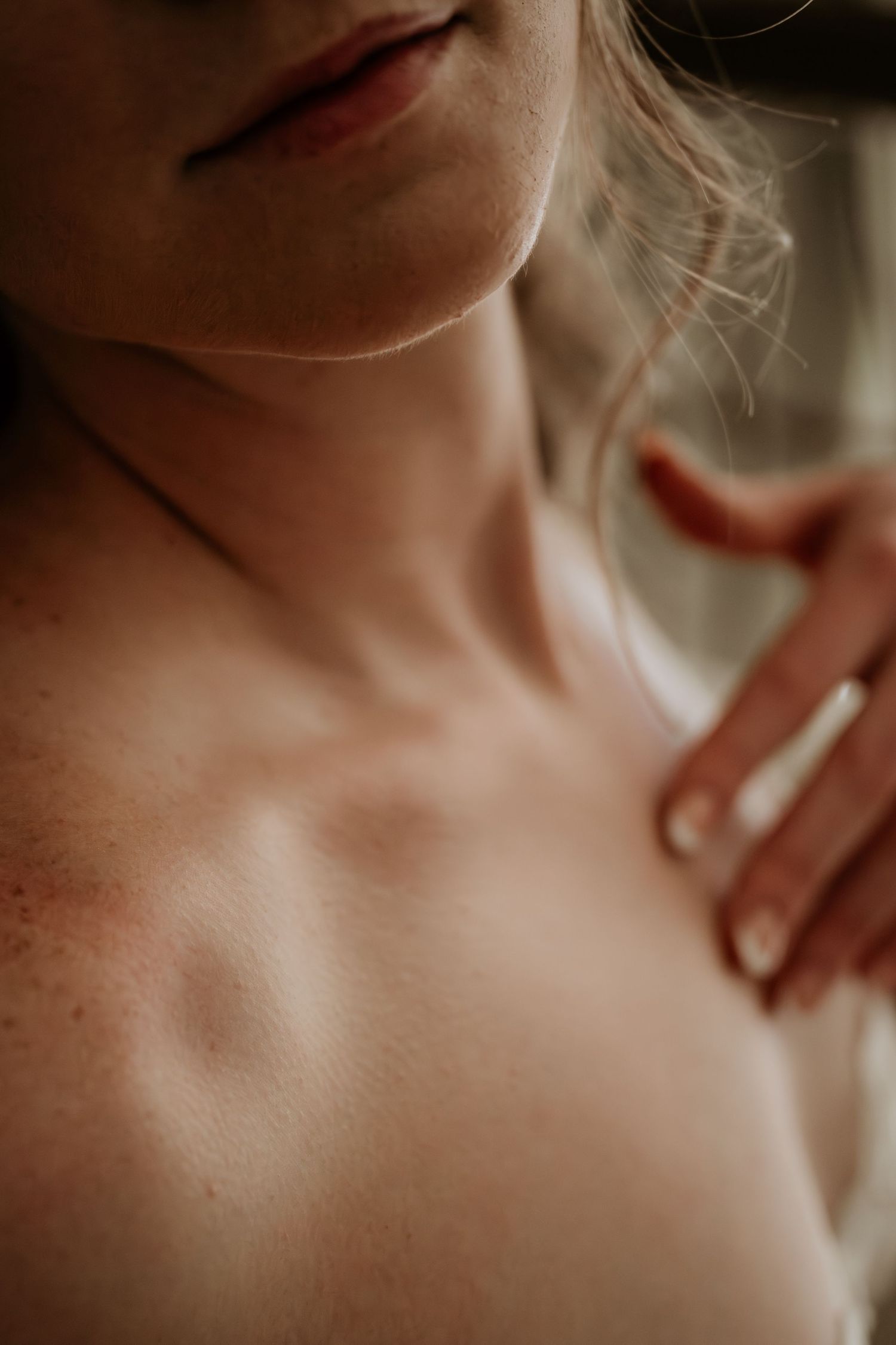 Artistic macro photography of skin and neck in soft, muted tones.