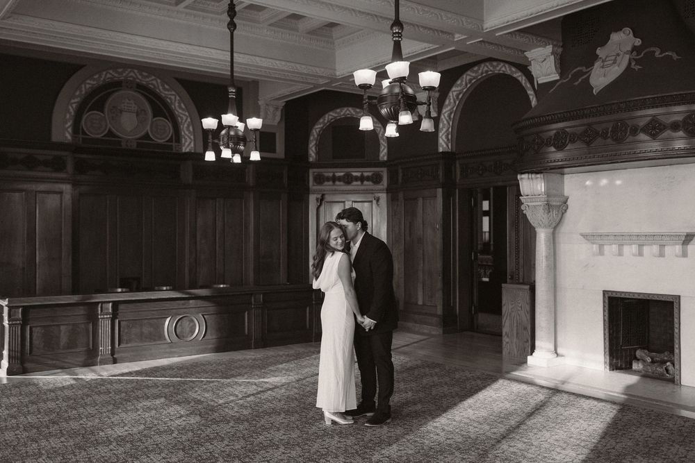 An elegant indoor venue with ornate architectural details and hanging chandeliers.