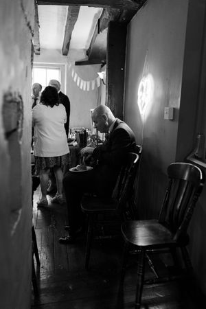 Black and white photographs show silhouettes of people moving through a dimly lit interior space.