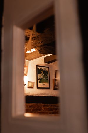 Five sequential photos showing warm-toned interior views through a small window opening in a rustic wall.