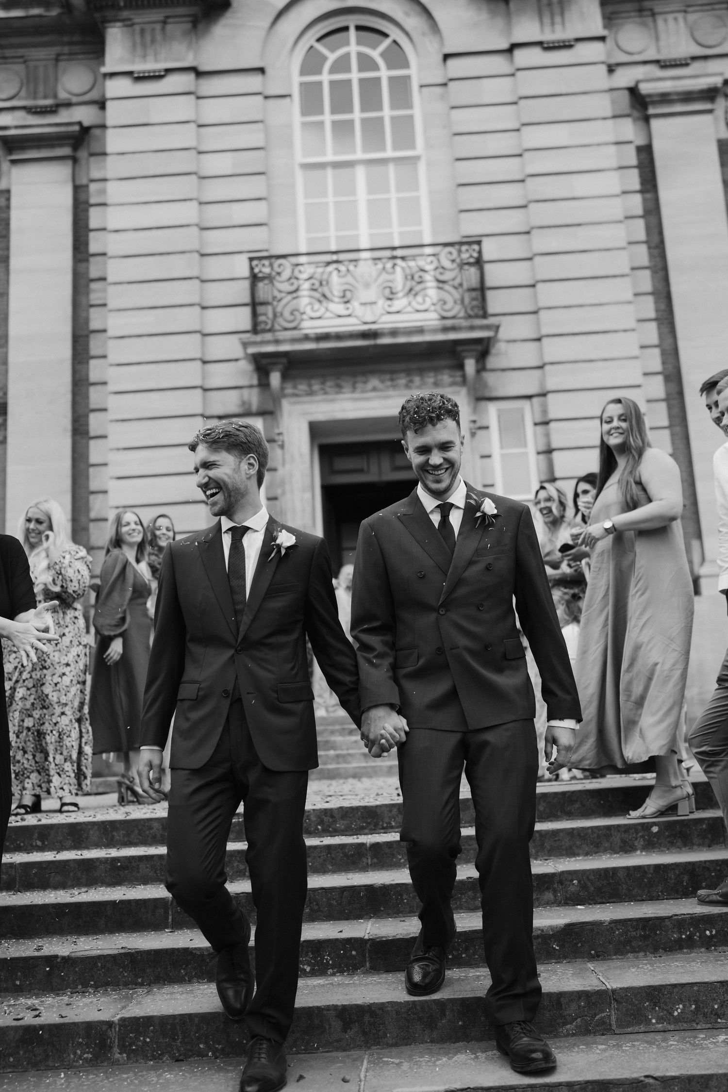groom and groom walking down steps in cotswolds