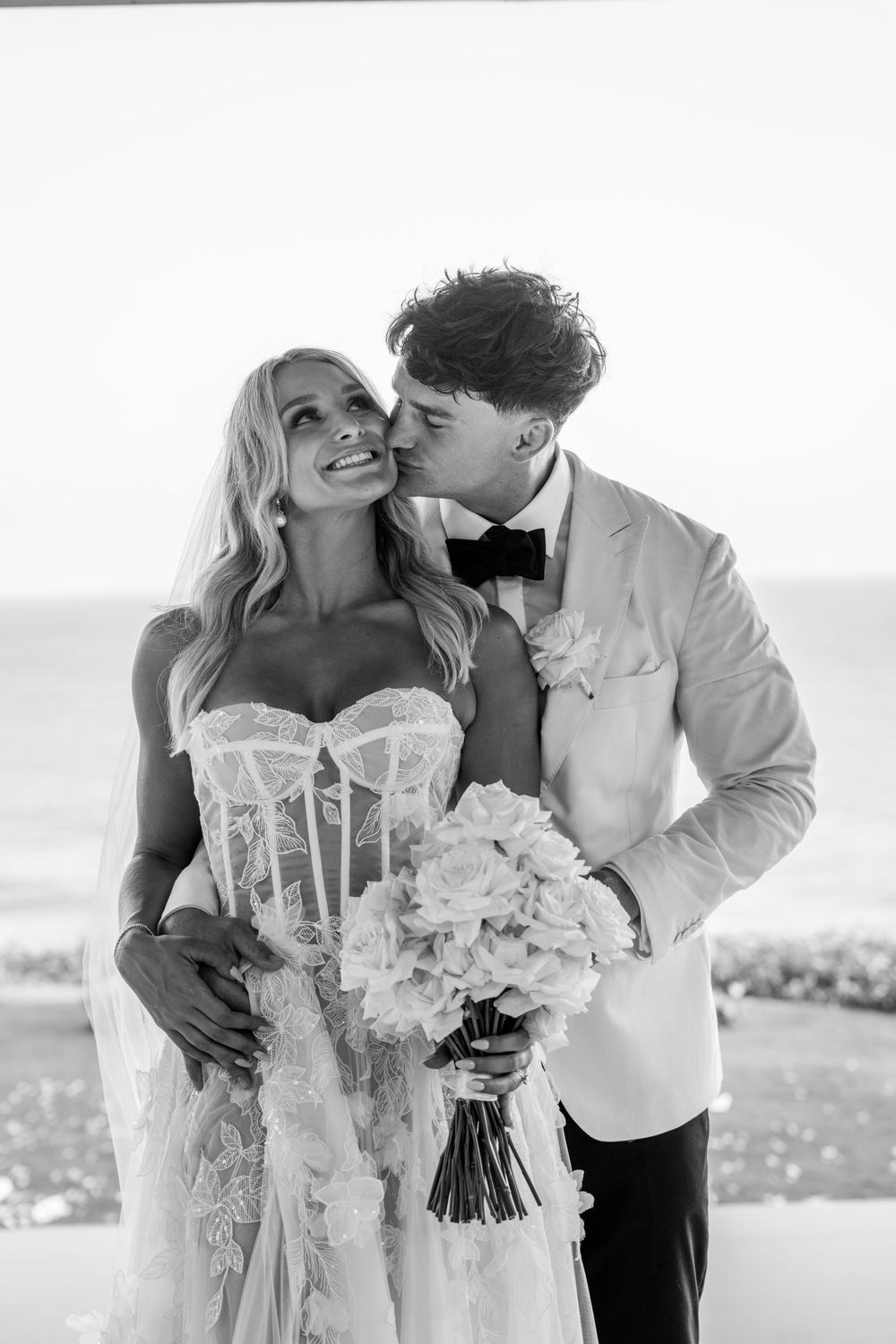 A romantic black and white wedding photo series showing intimate moments between newlyweds with a white floral bouquet.