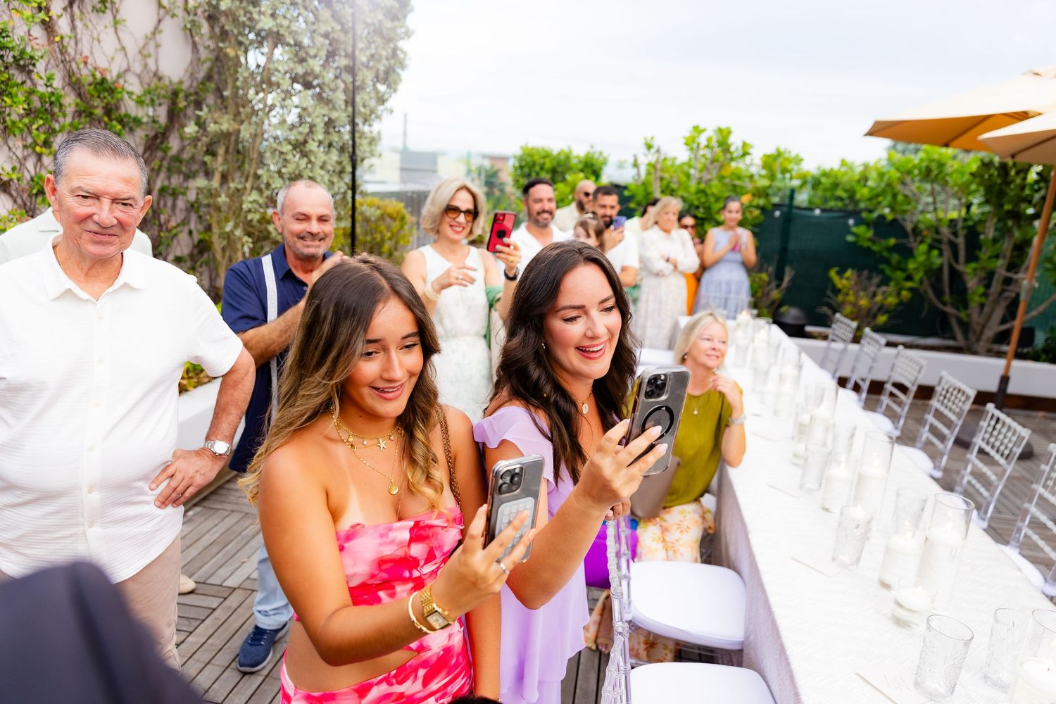 Joyful celebration with friends and family on an outdoor deck during a special moment.
