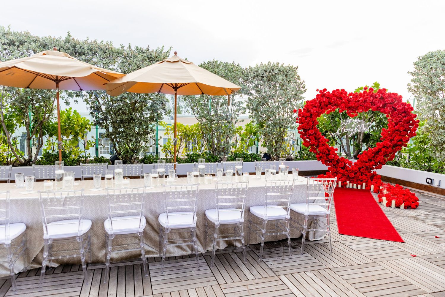 A row of connected outdoor wedding reception photos showing white chairs and red decorations on a deck overlooking water.